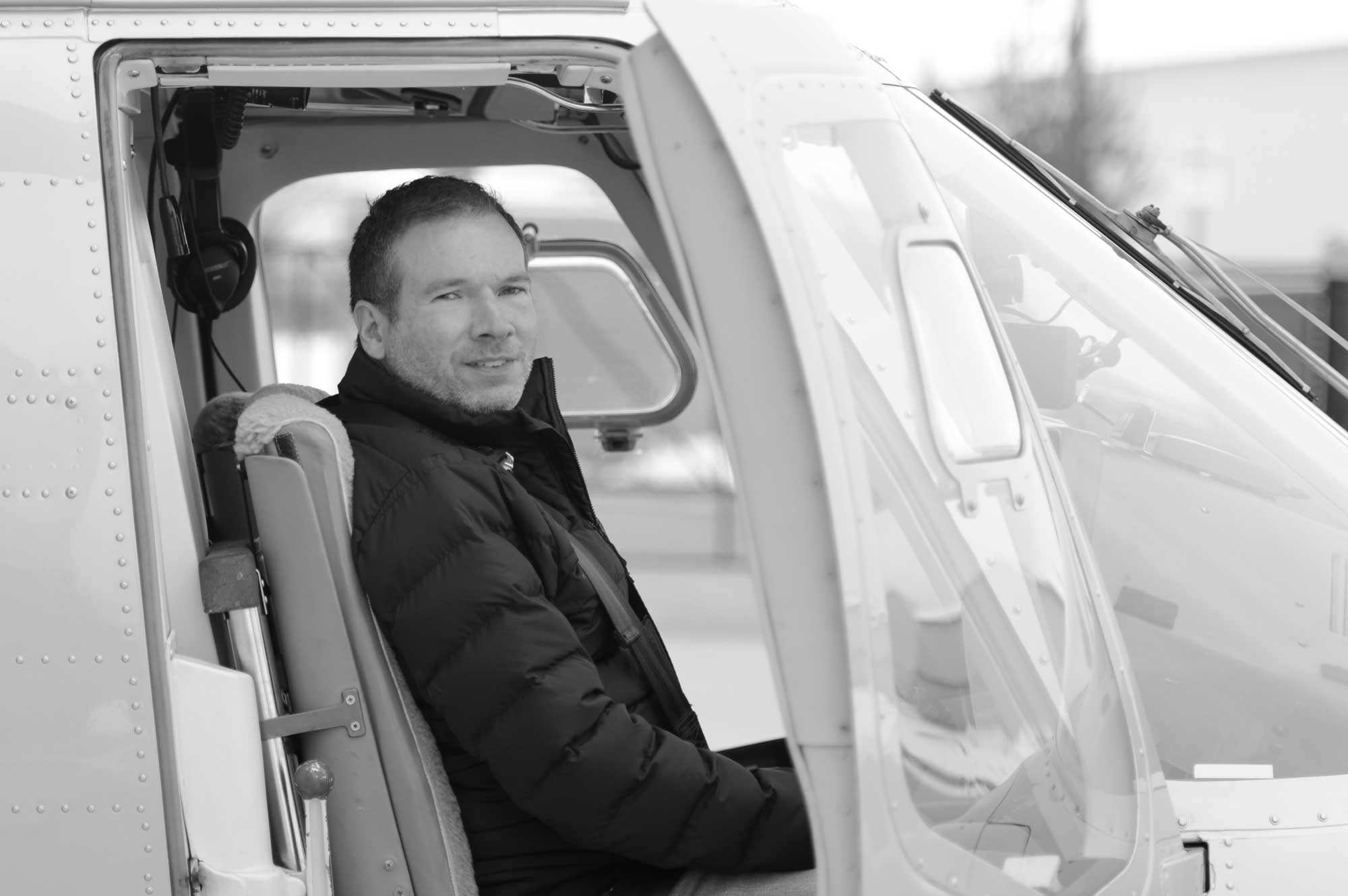 A man in front of a helicopter